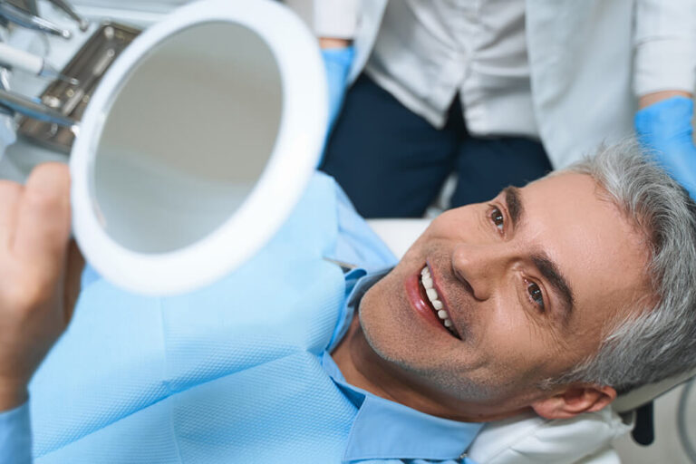 man at dentist office after smiling at cosmetic dental treatment